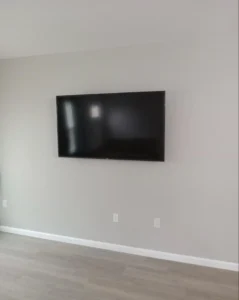 Professional TV wall mounting service with completely hidden cables for a minimalist living room in Houston.