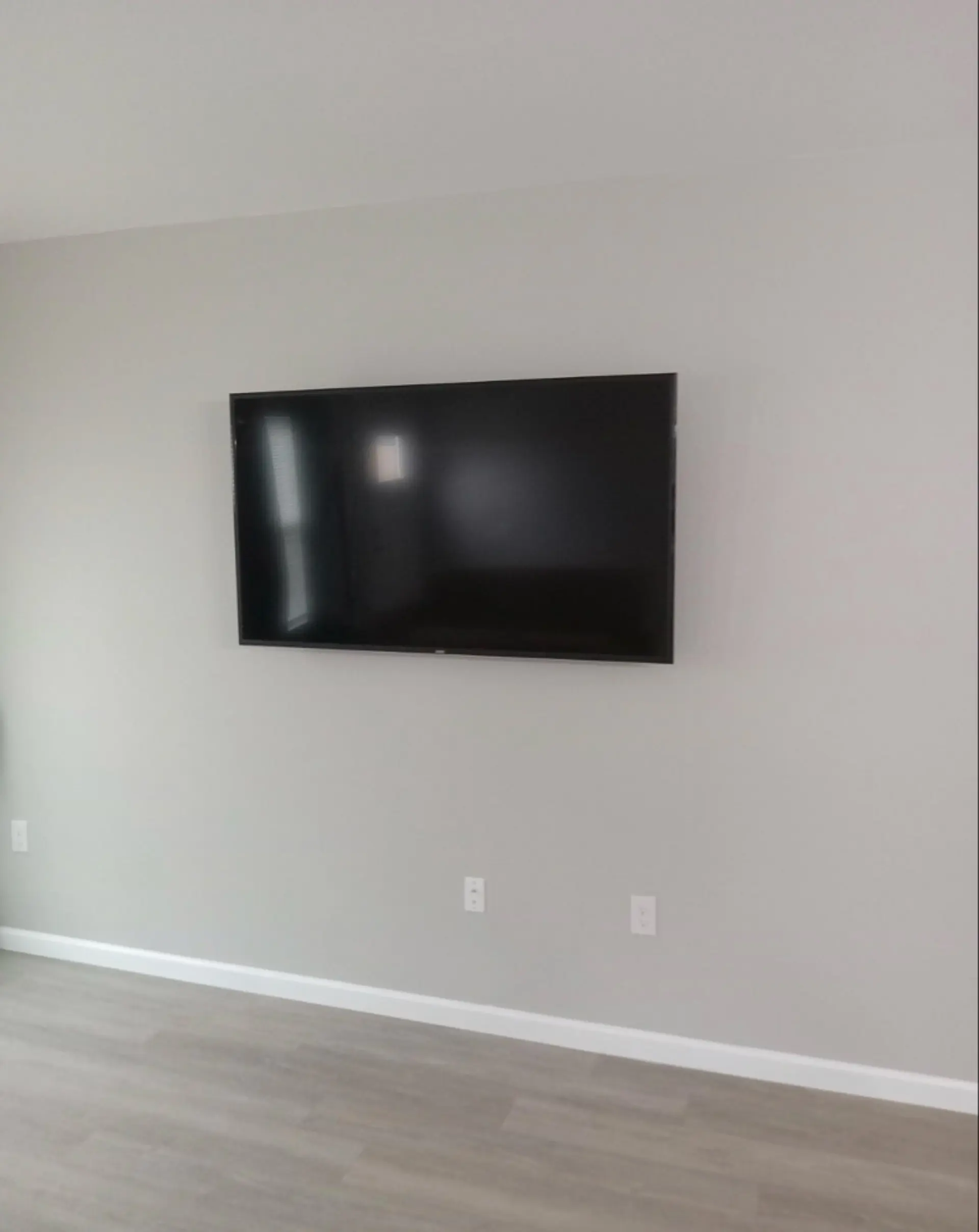 Professional TV wall mounting service with completely hidden cables for a minimalist living room in Houston.