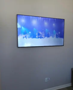 Expert TV installation on stone wall with seamless wire management for a clean, modern aesthetic.