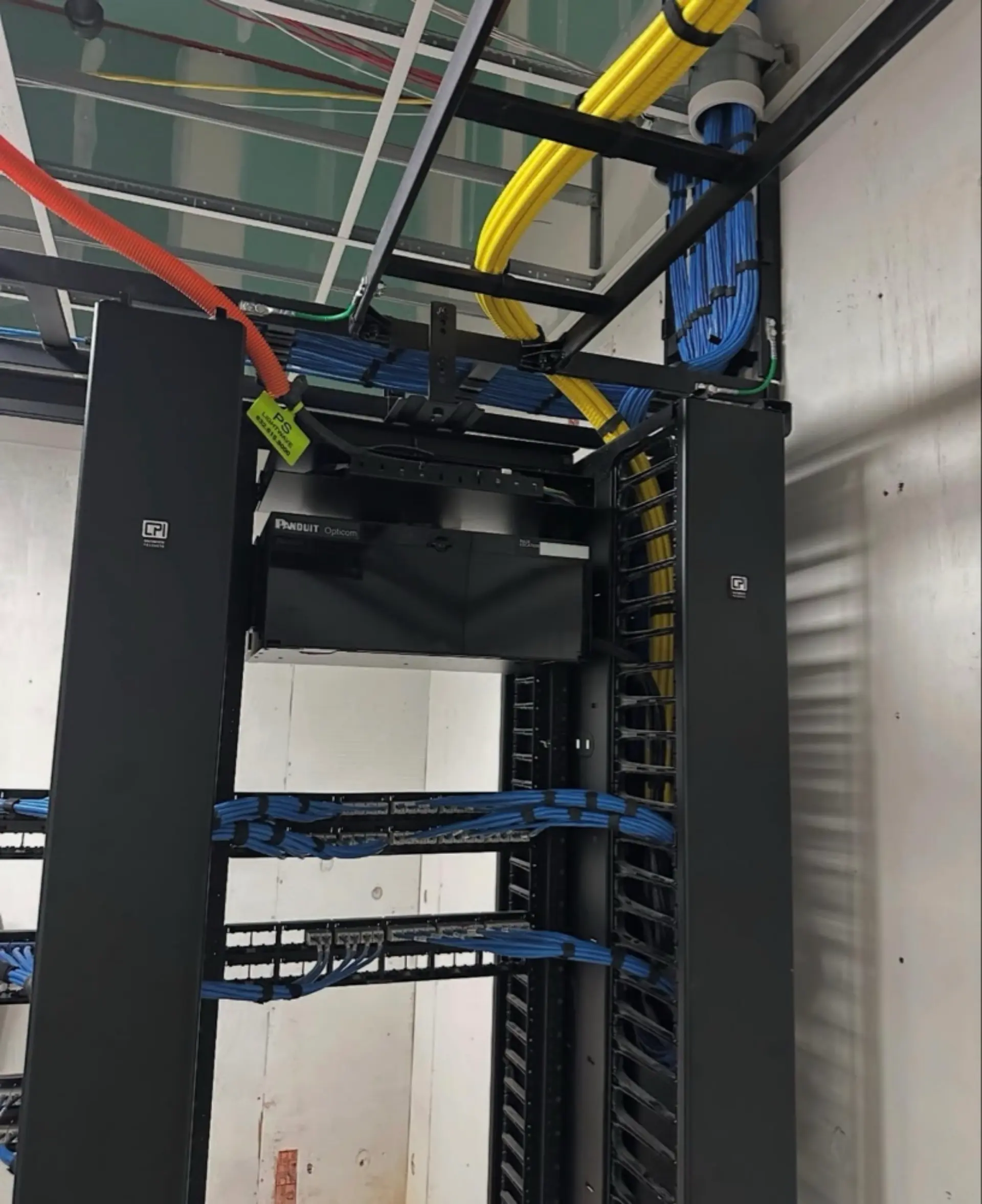 Technician performing professional network infrastructure setup and cable management for a reliable home and business network